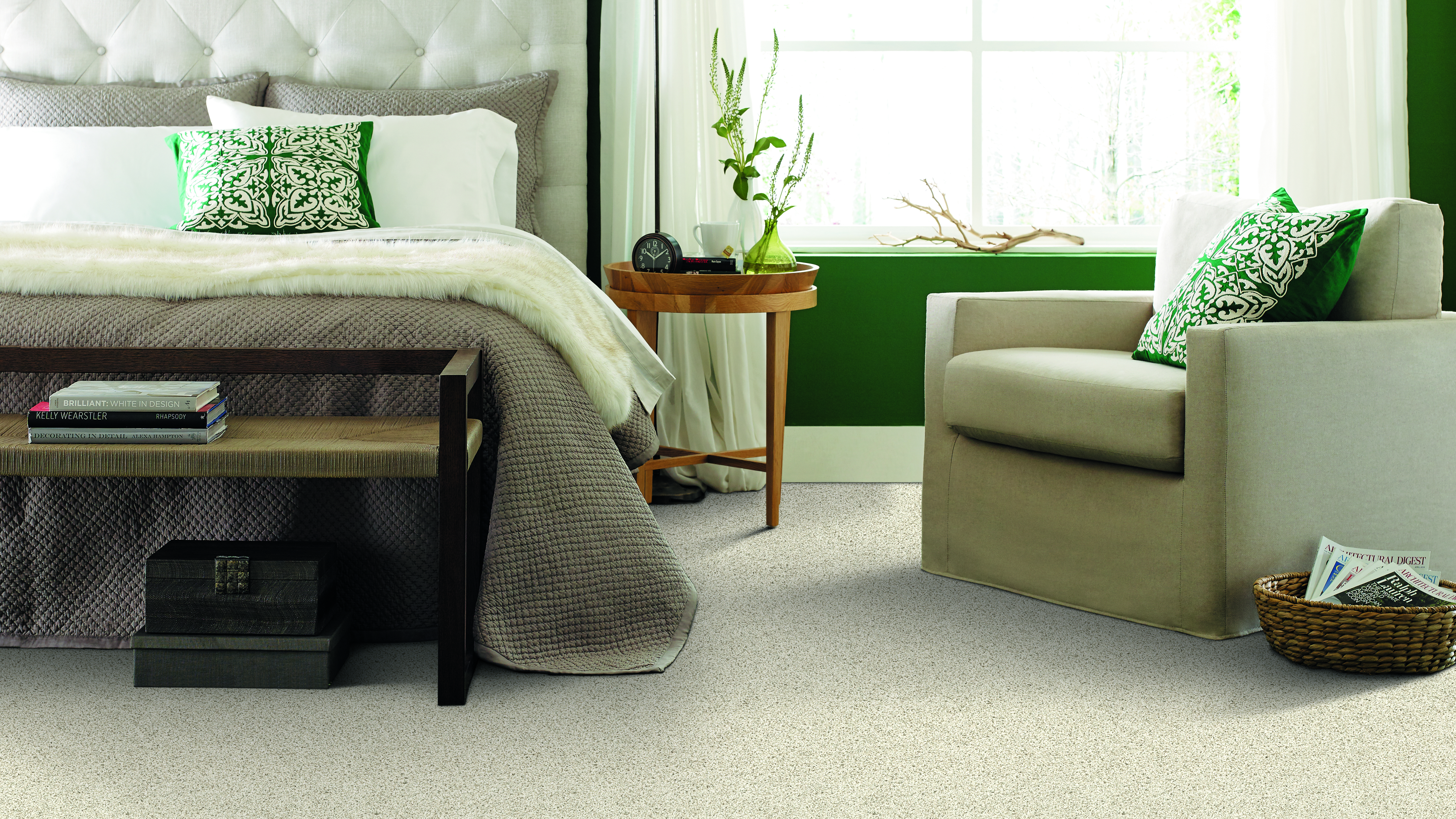 Carpet Flooring with a bedroom with a bed and chair decorated with green pillows 